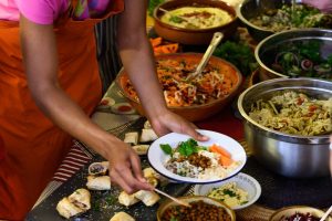 A woman serving herself from a table full of food