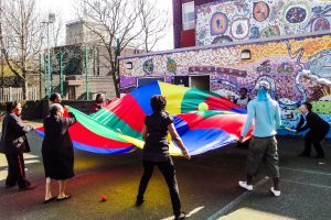 Children outside waving a colourful banner