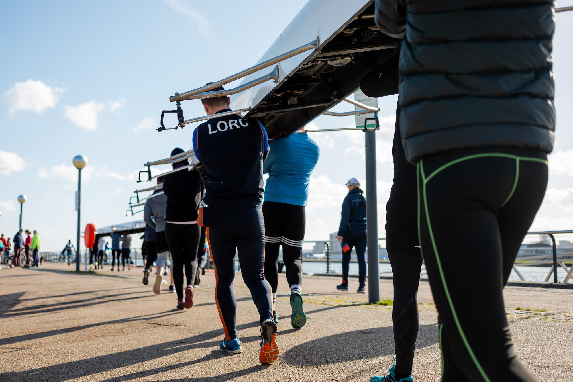 rowers carrying a boat on their shoulders