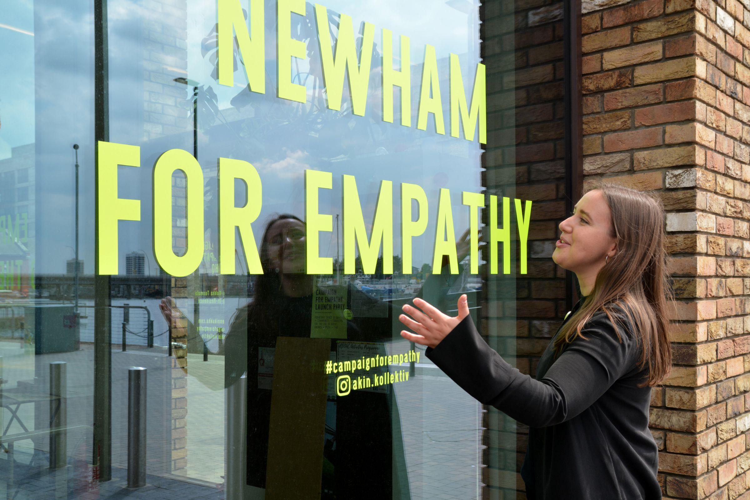 Enni-Kukka Tuomala in front of Newham For Empathy window sign