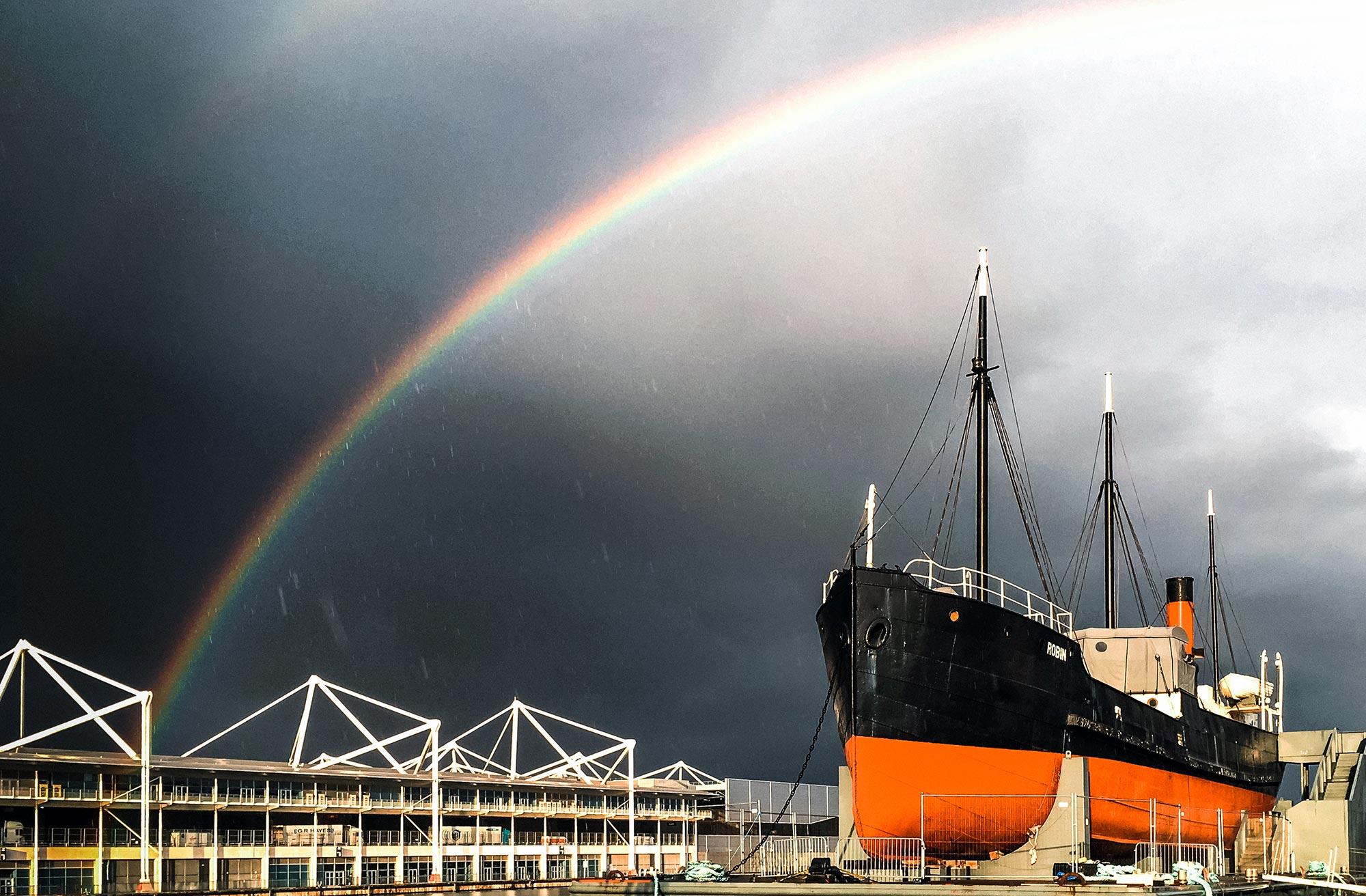 SS Robin in the Royal Docks with a rainbow in the sky