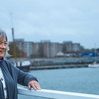 Marian Phillips on a bridge overlooking the Royal Docks