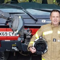 Paul Foster standing by a London City Fire Brigade truck