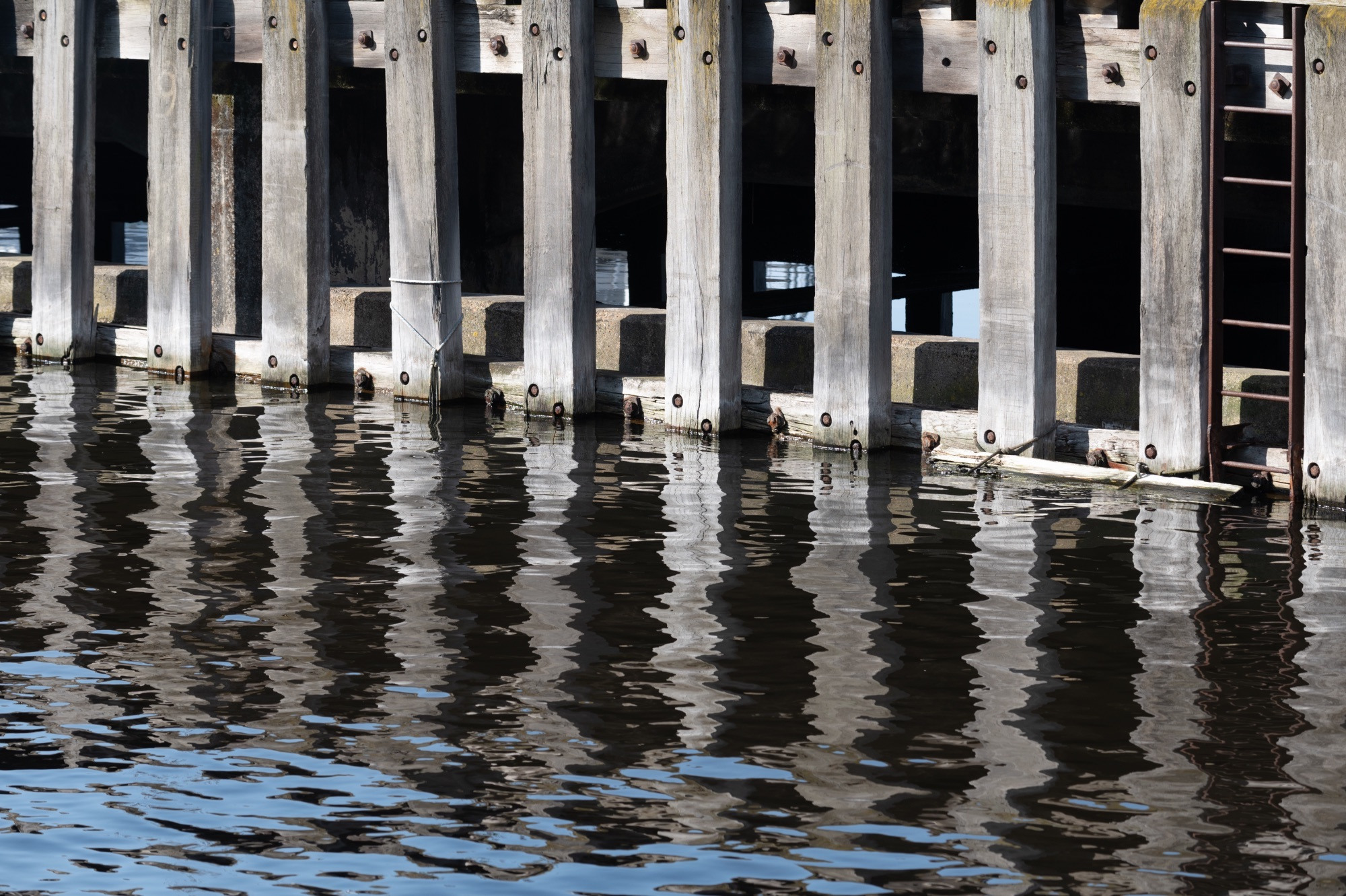 A pier mirrored on the water