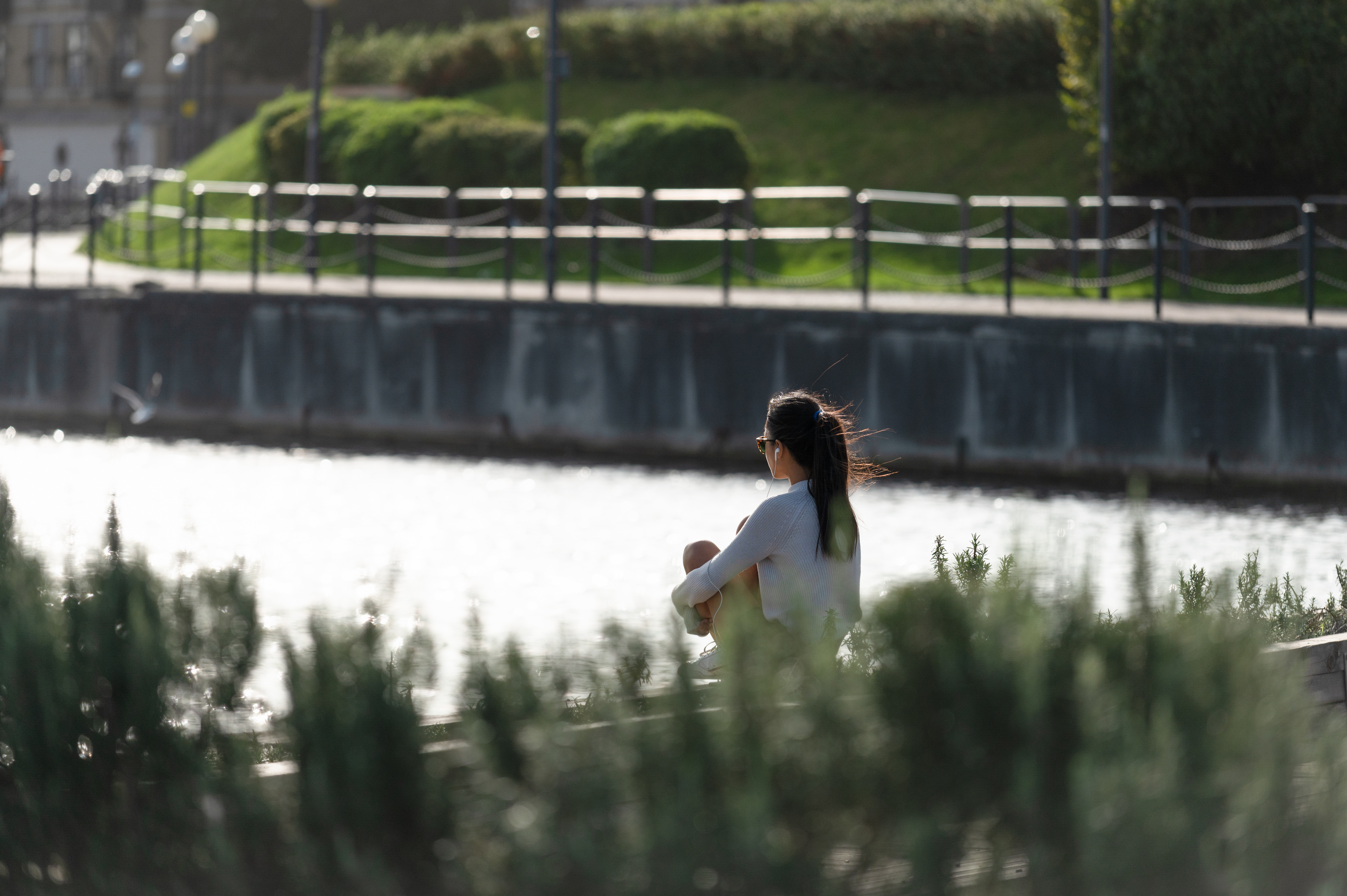 A woman sitting and looking out on the dock water