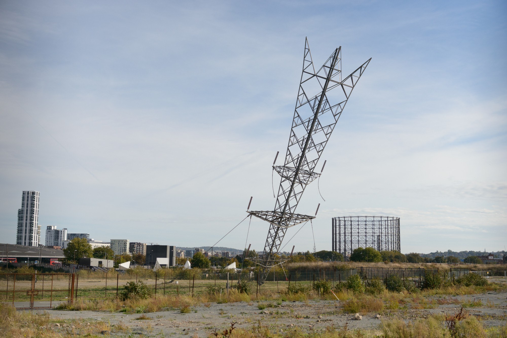 Sculpture that appears to be an electricity pylon that has crashed landed into the earth head first