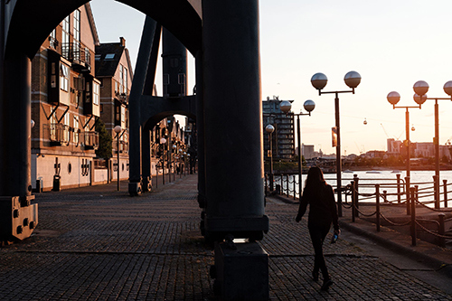 A photo of a person walking among the cranes in the Royal Docks