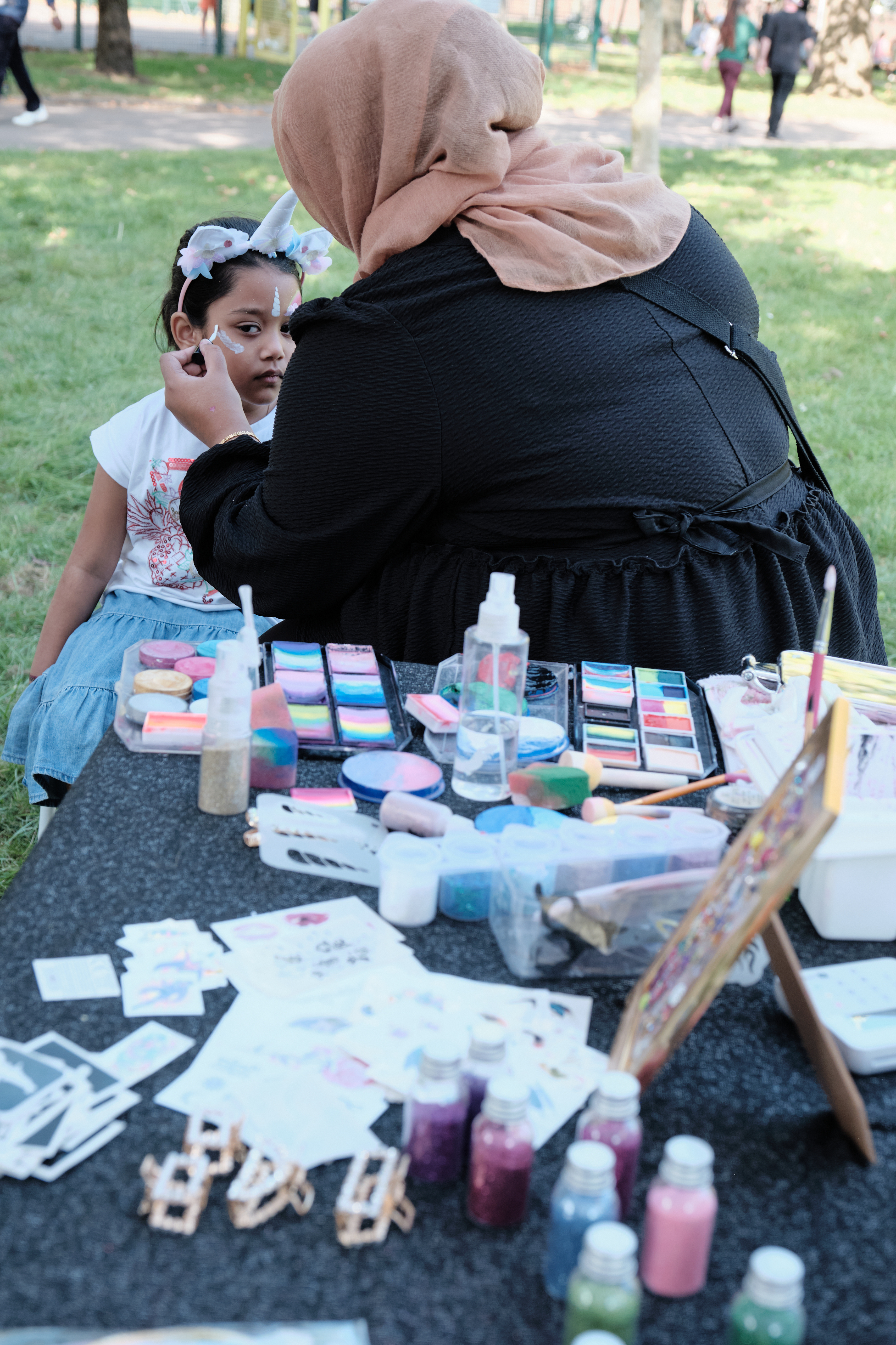 Young girl is face painted by artist