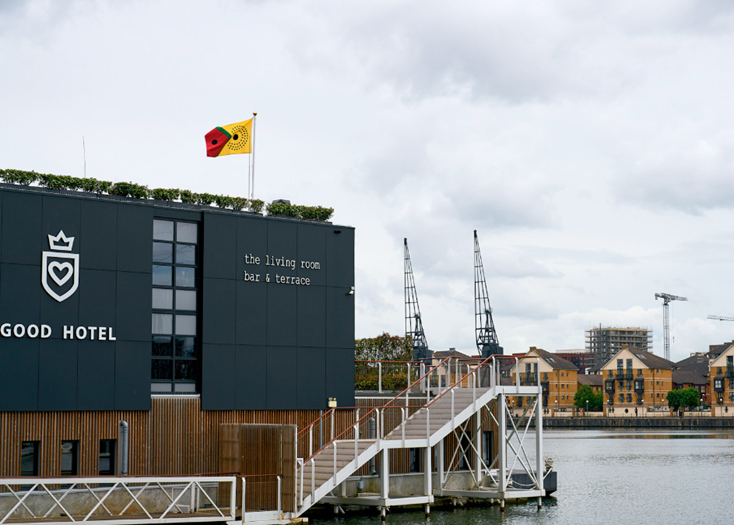 A photo of the Sanko Time flag atop the Good Hotel in the Royal Docks
