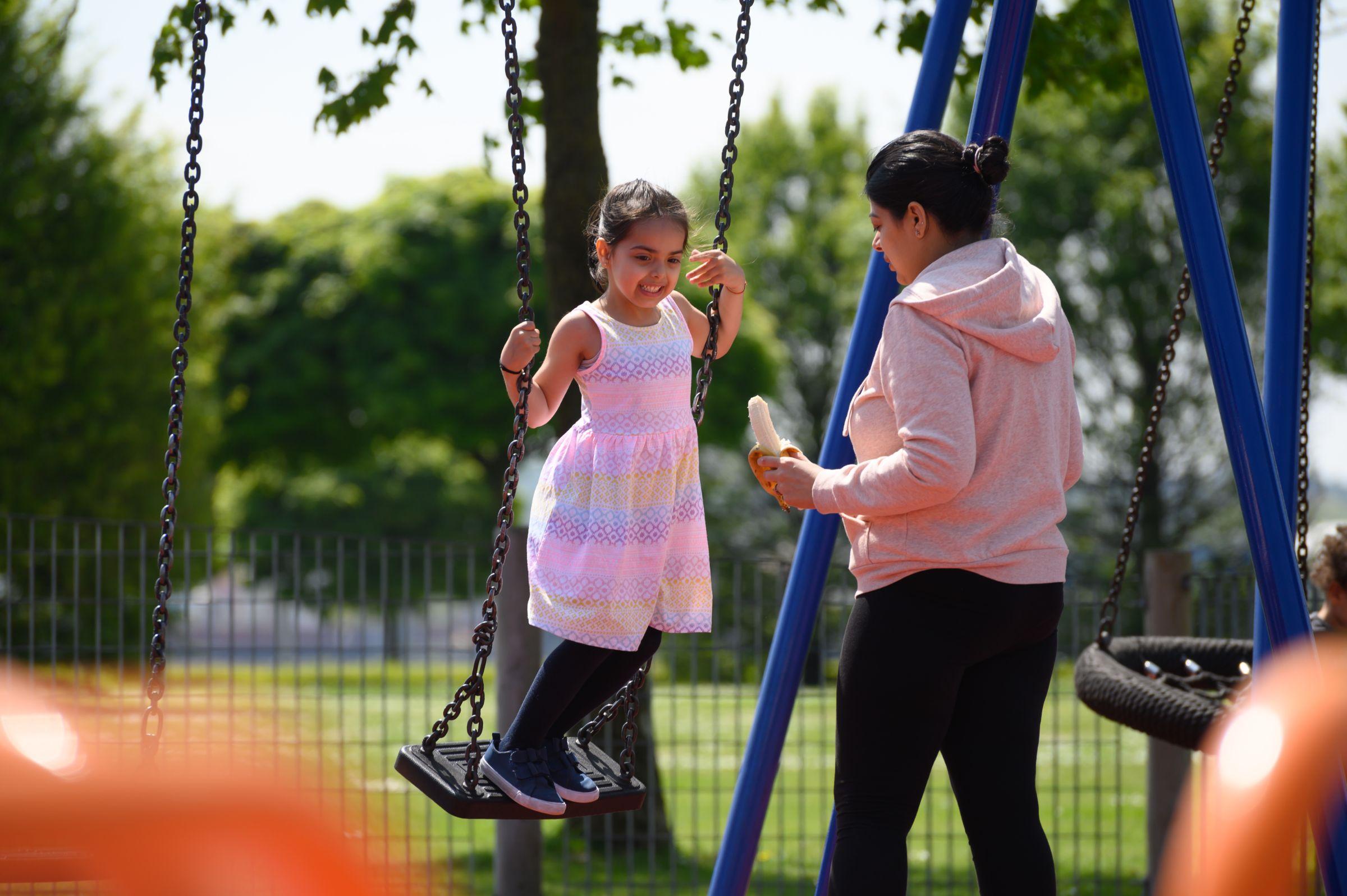 Woman and child playing on a swing