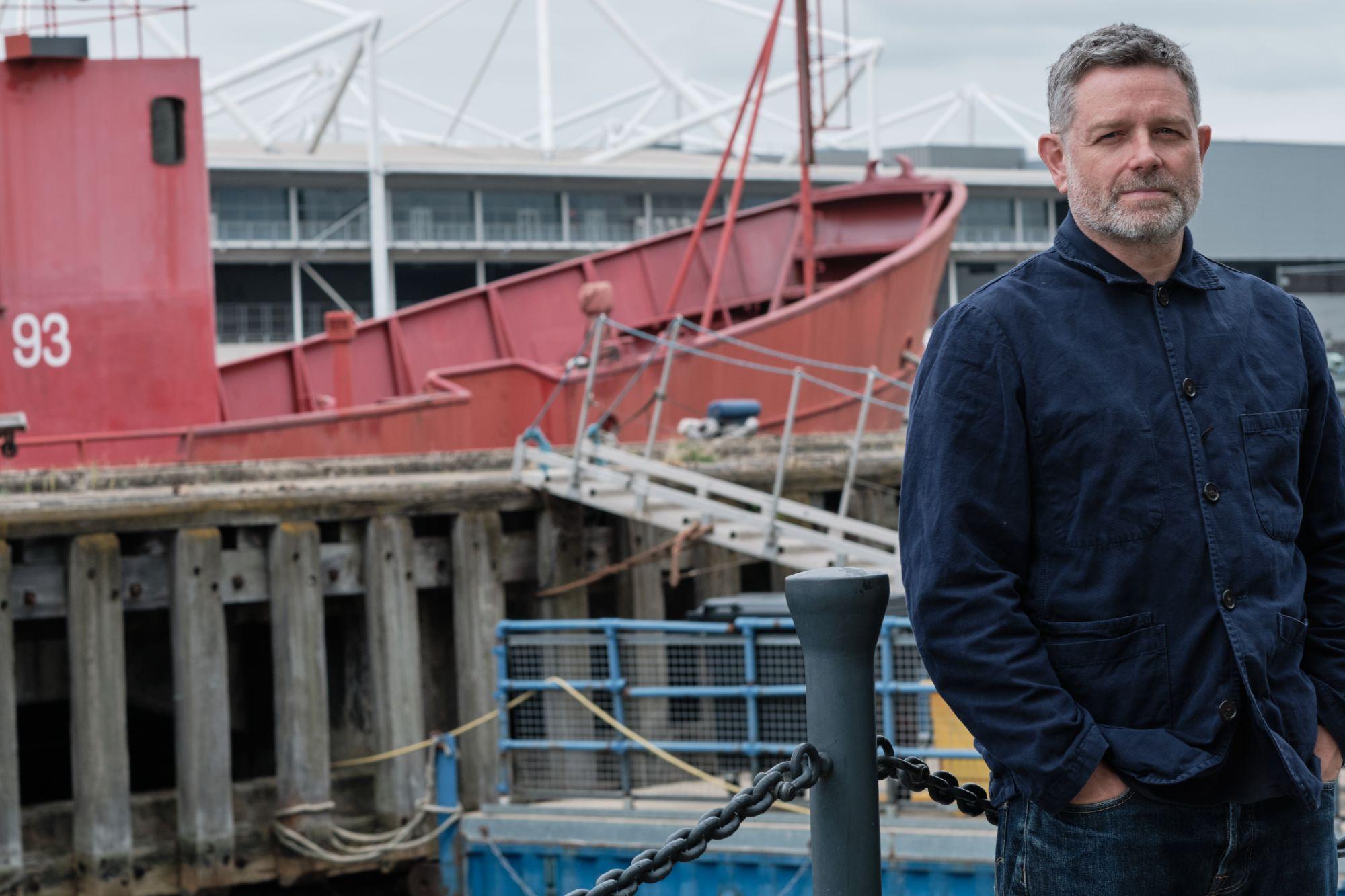 Matthew standing in front of a boat