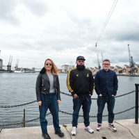 The Arrival team standing in front of the dock water