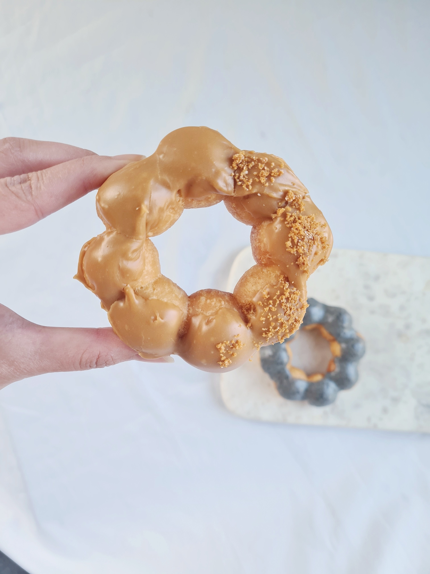 A donut shaped out of dough balls with brown icing