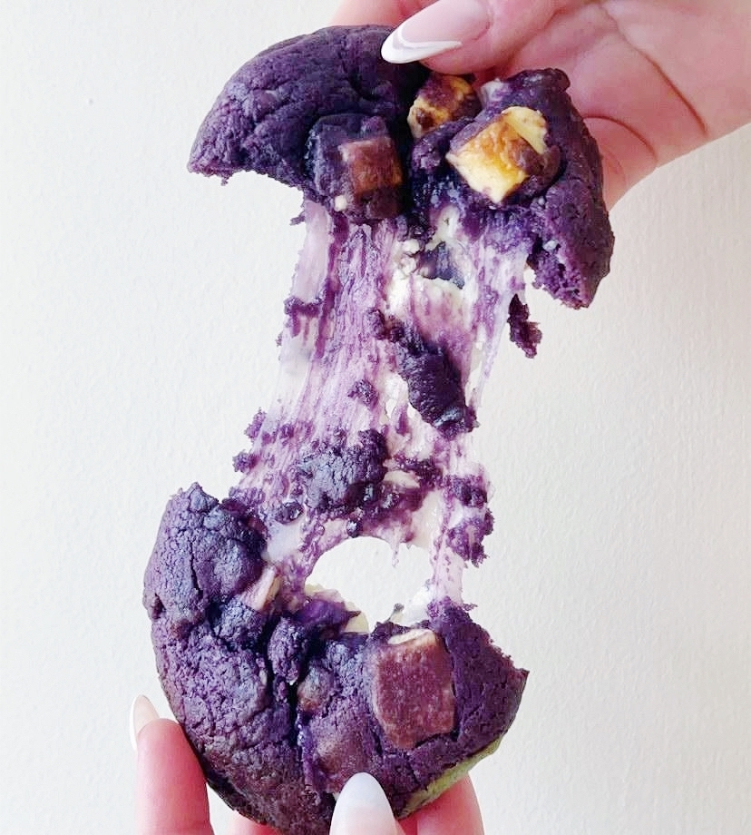 A purple cookie being pulled apart, showing its gooey centre