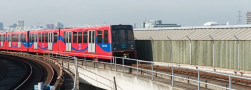 DLR train travelling along the tracks in the Royal Docks