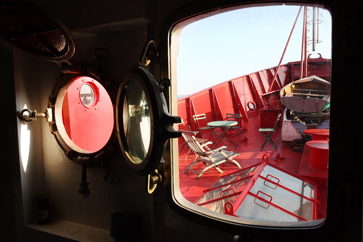 Looking out from an opening in the boat onto the red deck at one end