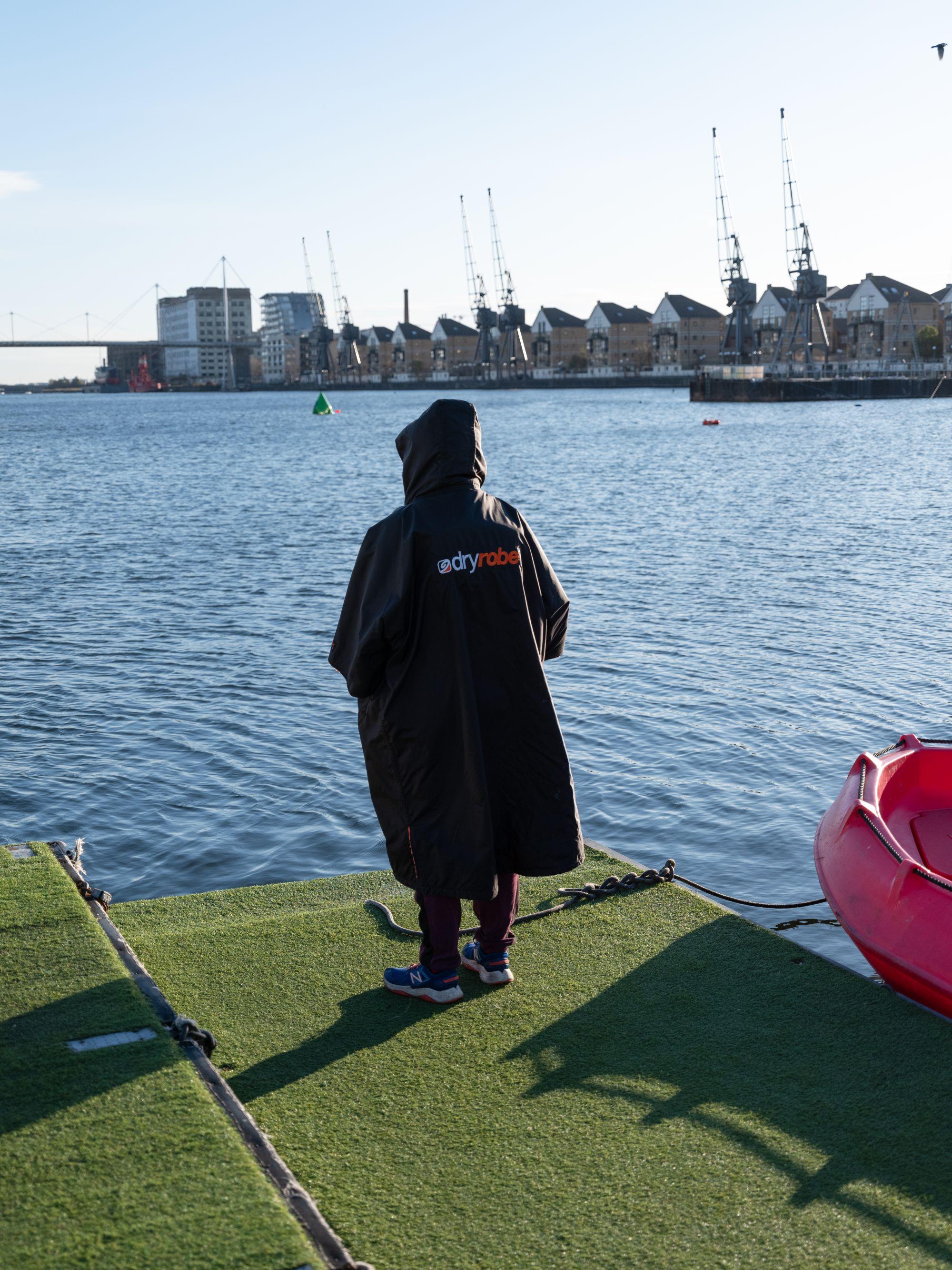 A person in a dryrobe surveys the water