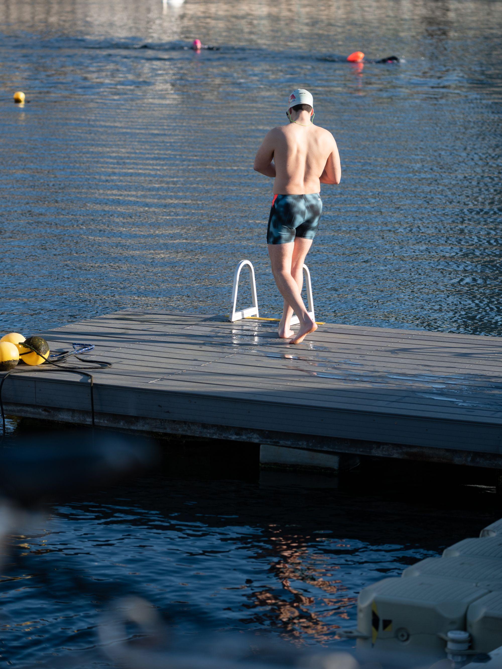 A man in trunks approaches the water
