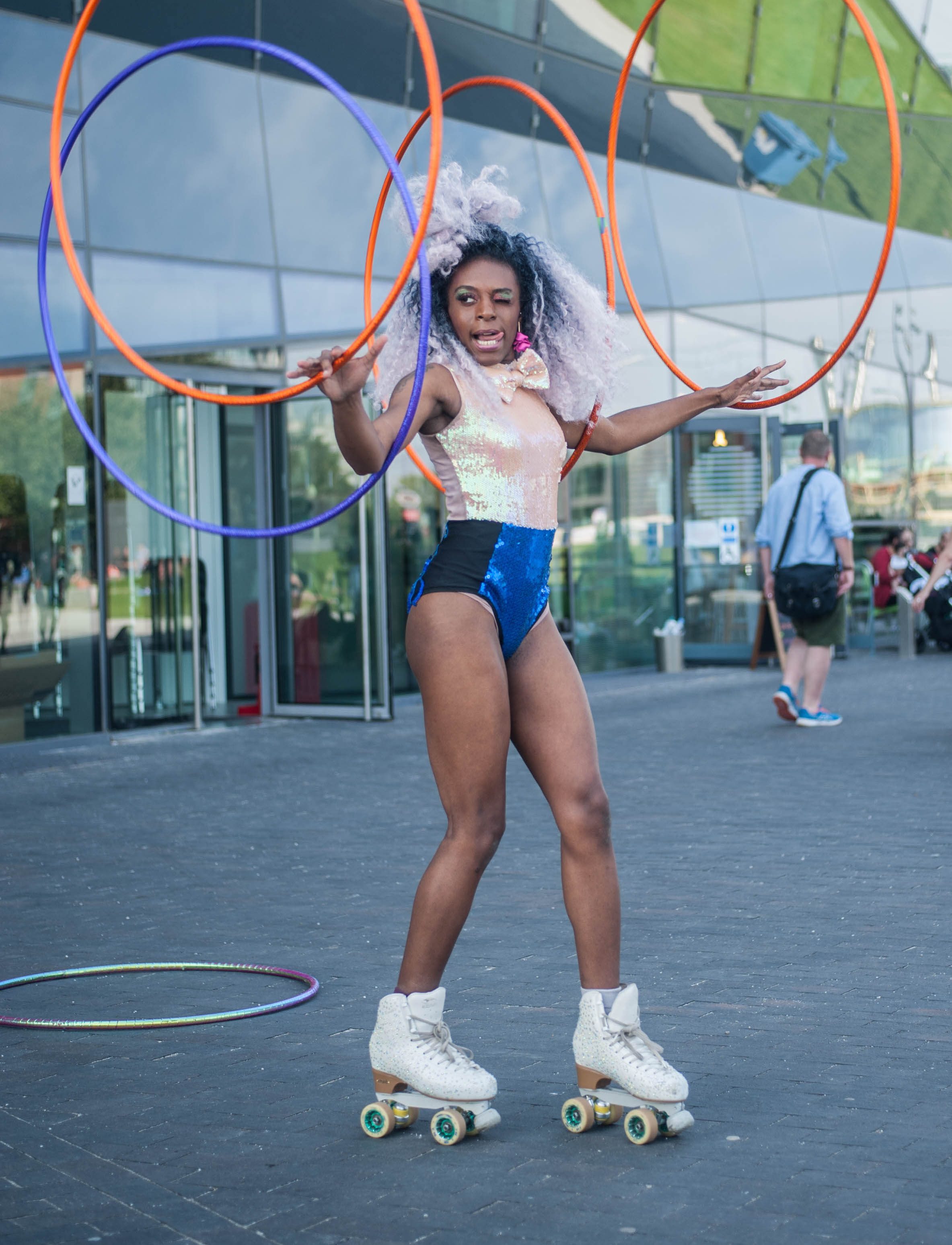 A woman wearing rollerskates carrying hula hoops