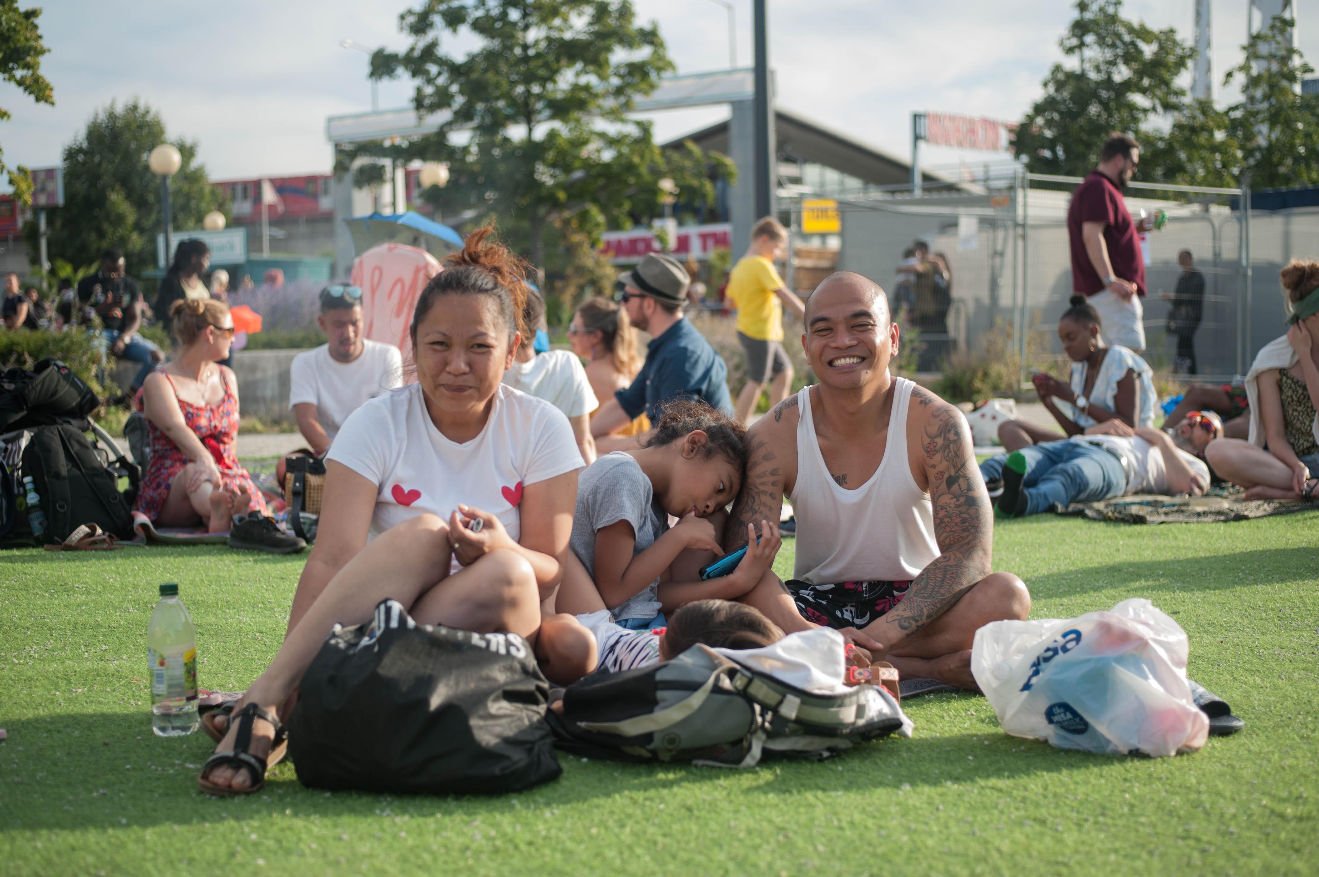 A photo of a family sitting on the grass and smiling