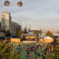 A crowd watching a band perform with the Emirates Cable Car overhead