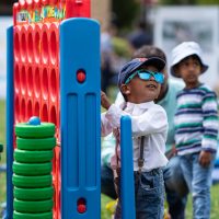 A boy in sunglasses playing with colourful toys