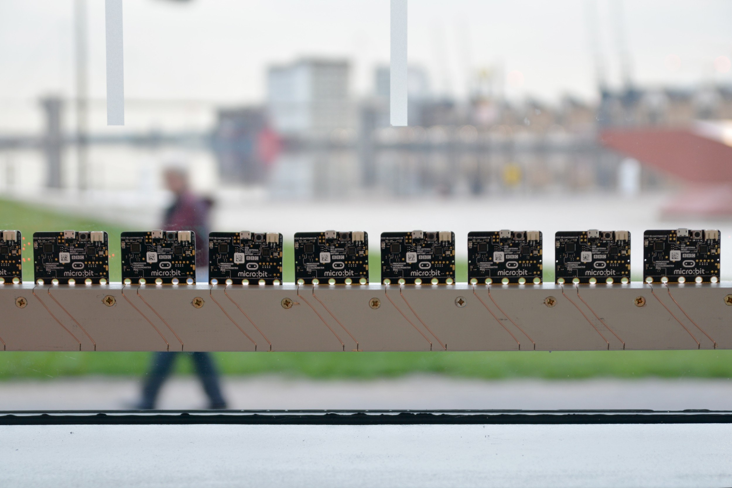 Photo of the backs of a row of multiple LED lights with the Royal Docks in the background