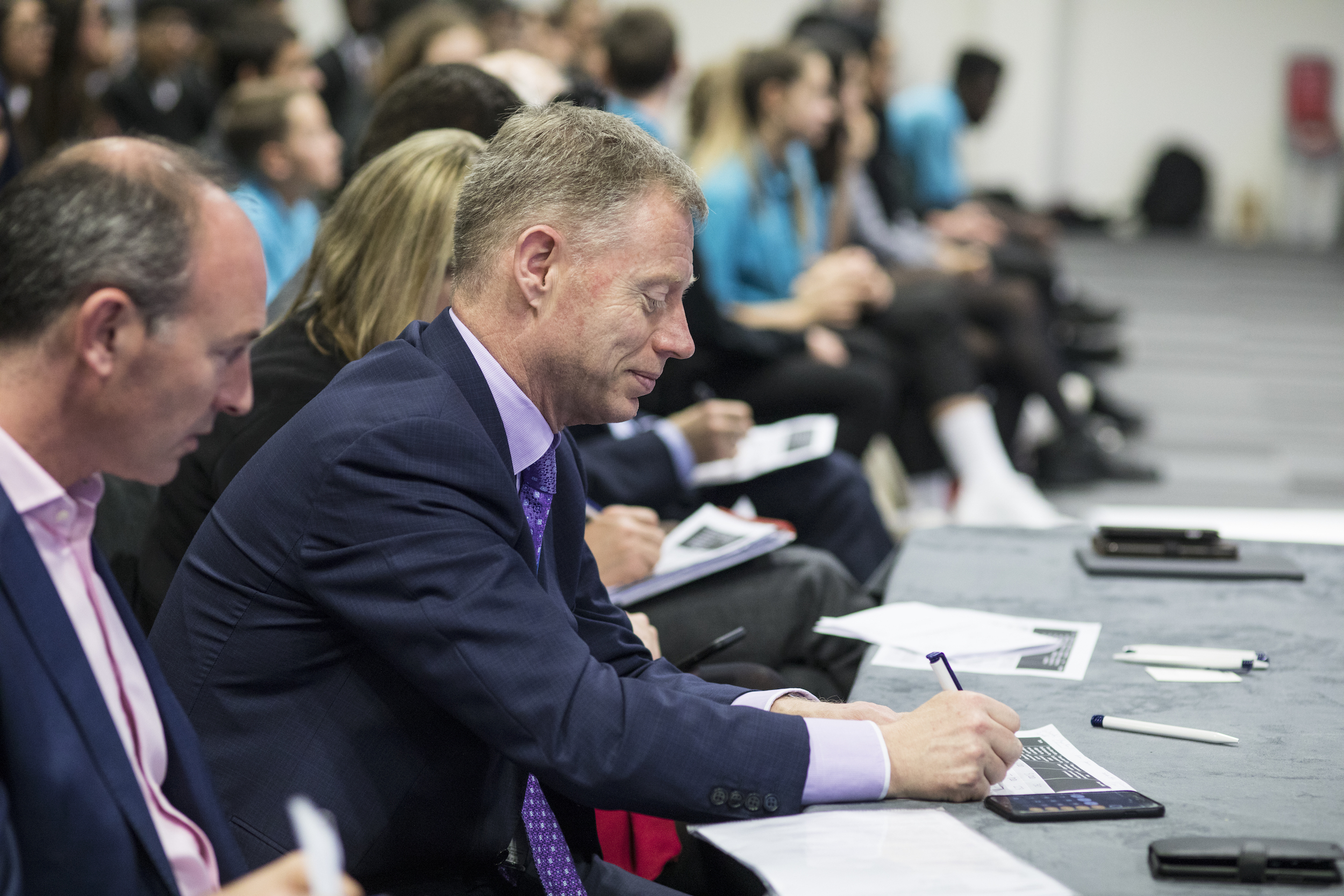 LCY CEO Robert Sinclair sitting on a judging panel, with a slight smile on his face making notes