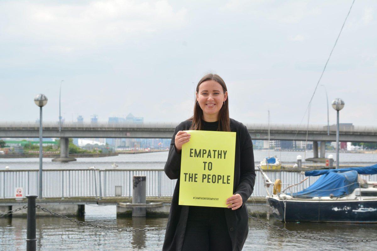 Artist Enni-Kukka Tuomala holding an 'Empathy To The People' sign