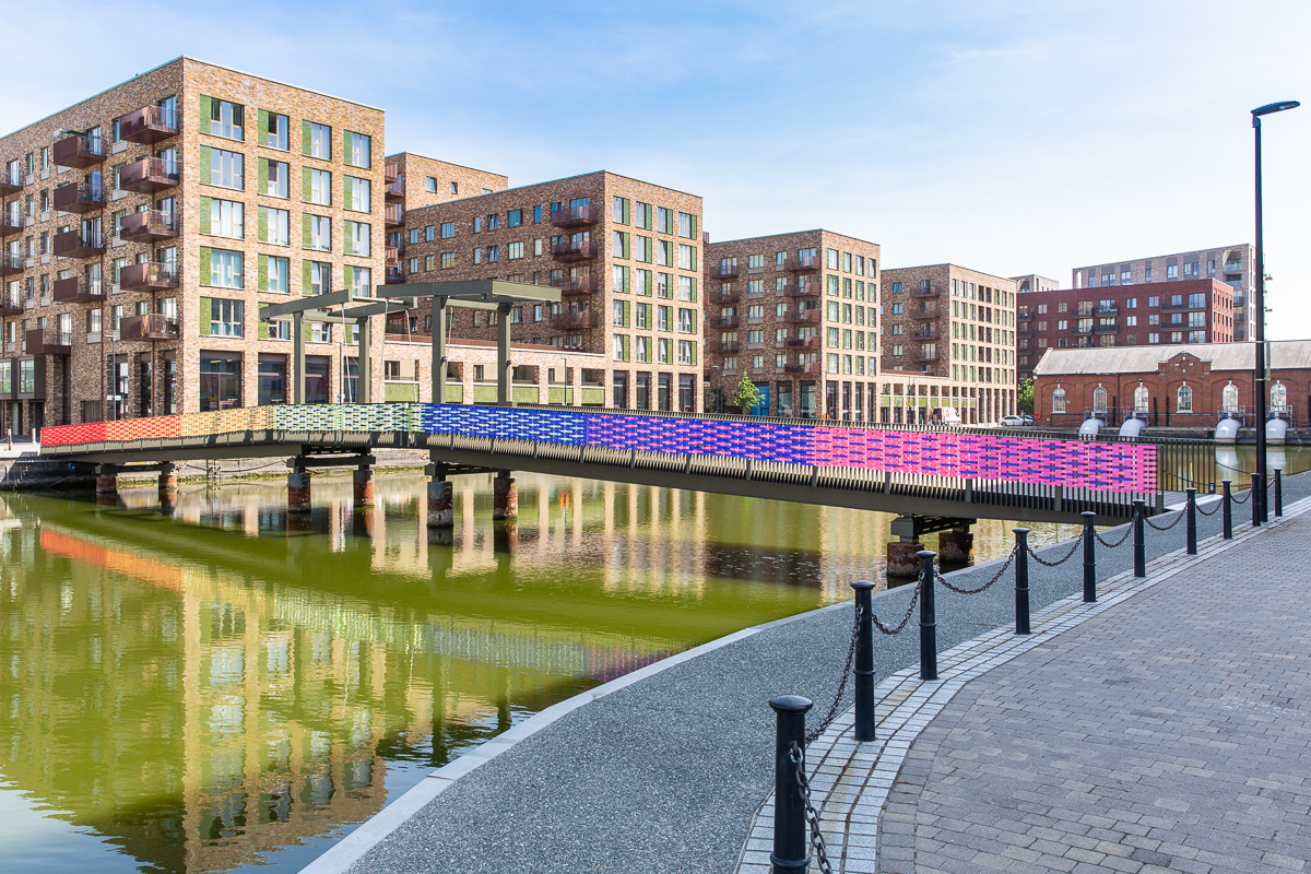 Bridge over Royal Albert Wharf decorated from end to end in rainbow ribbon