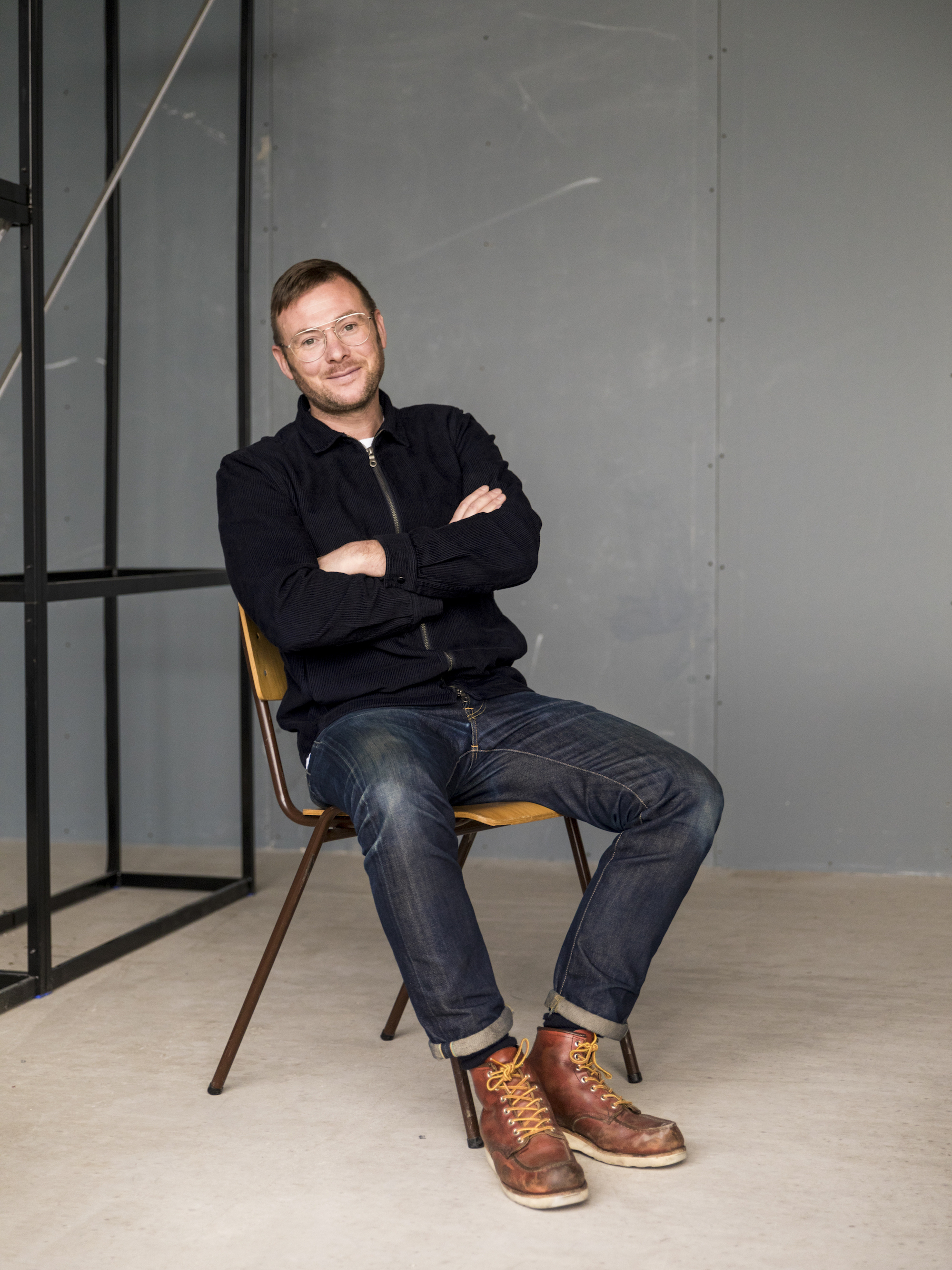 Portrait of Nick Hartwright leaning back in a chair, smiling with his arms folded