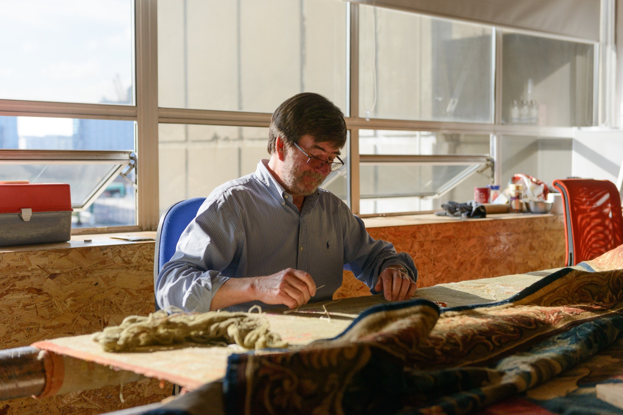 Man working on tapestry