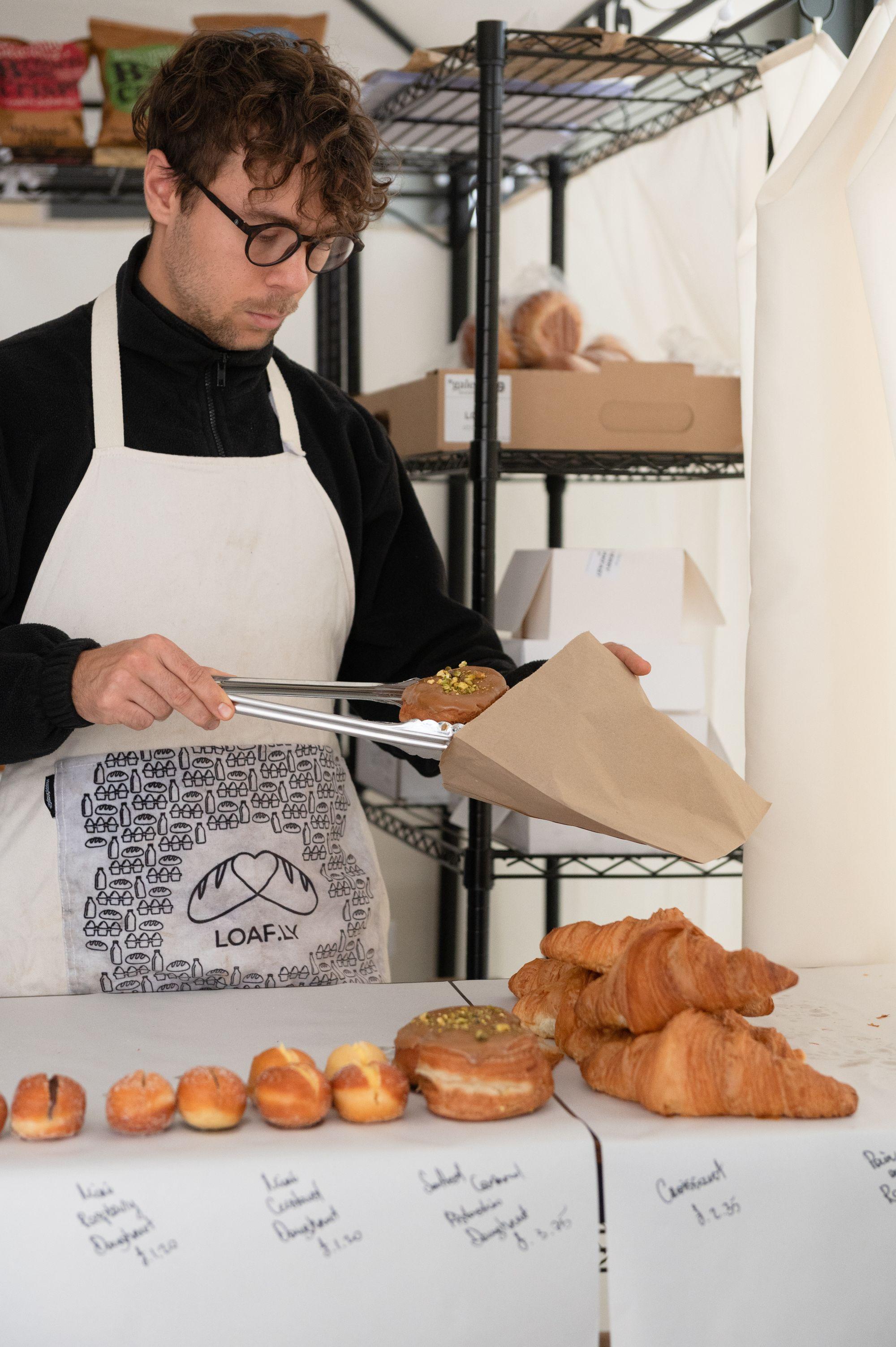 Pastries being put in a bag by a loafly employee