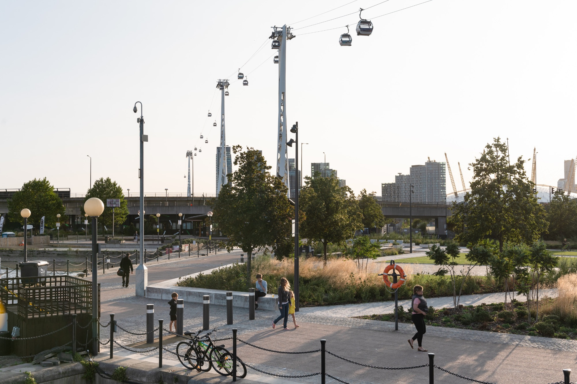 Sunset scene next to Royal Victoria Dock, with gardens and the cable car running overhead