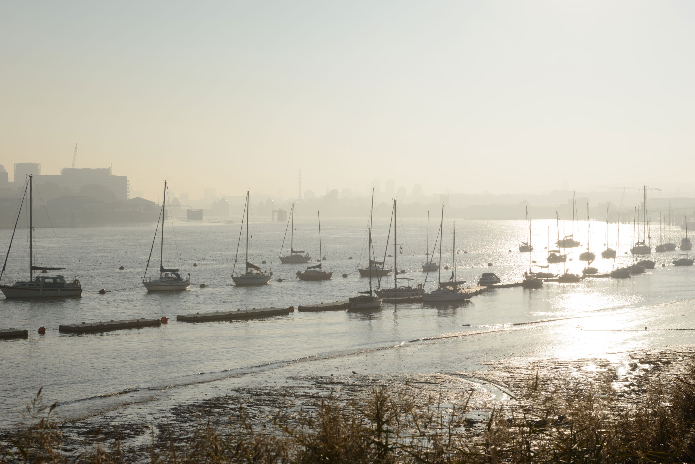 Boats in the Thames off the Royal Docks in hazy sun