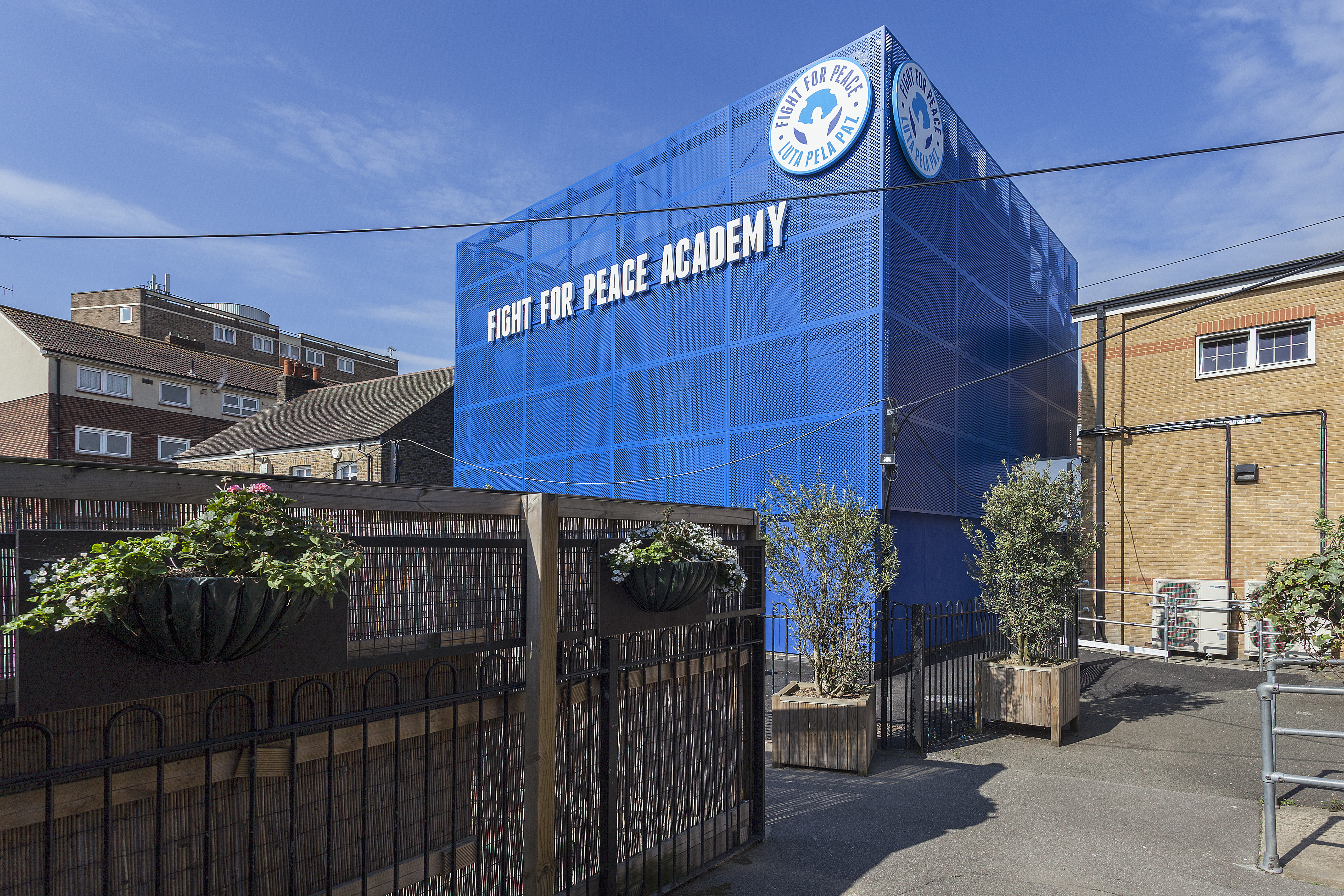 Striking blue building a few storeys high that says Fight for Peace academy on it