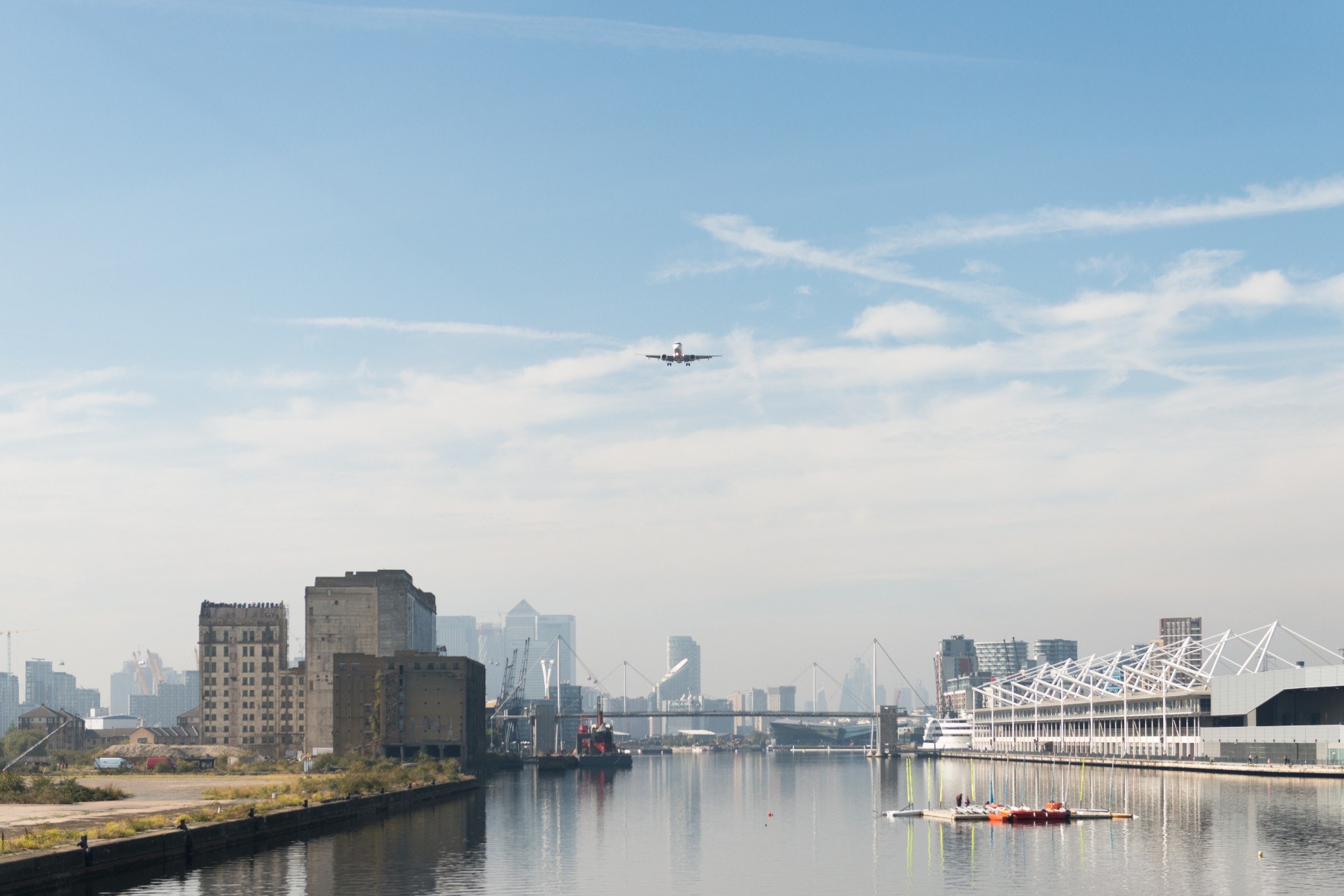 Plane in the sky having departed London City Airport with Canary Wharf in the background