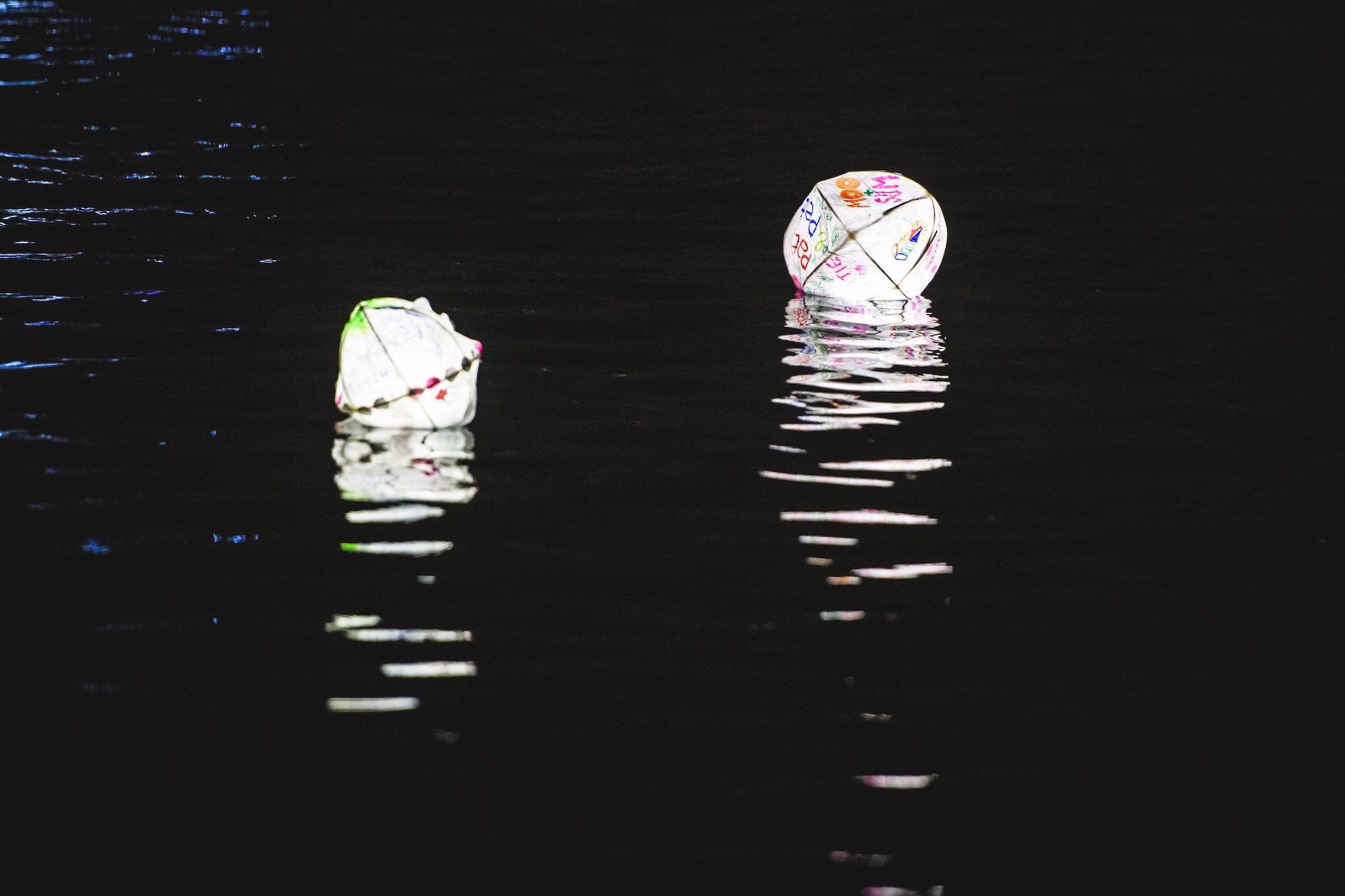 Lanterns floating on water after dark