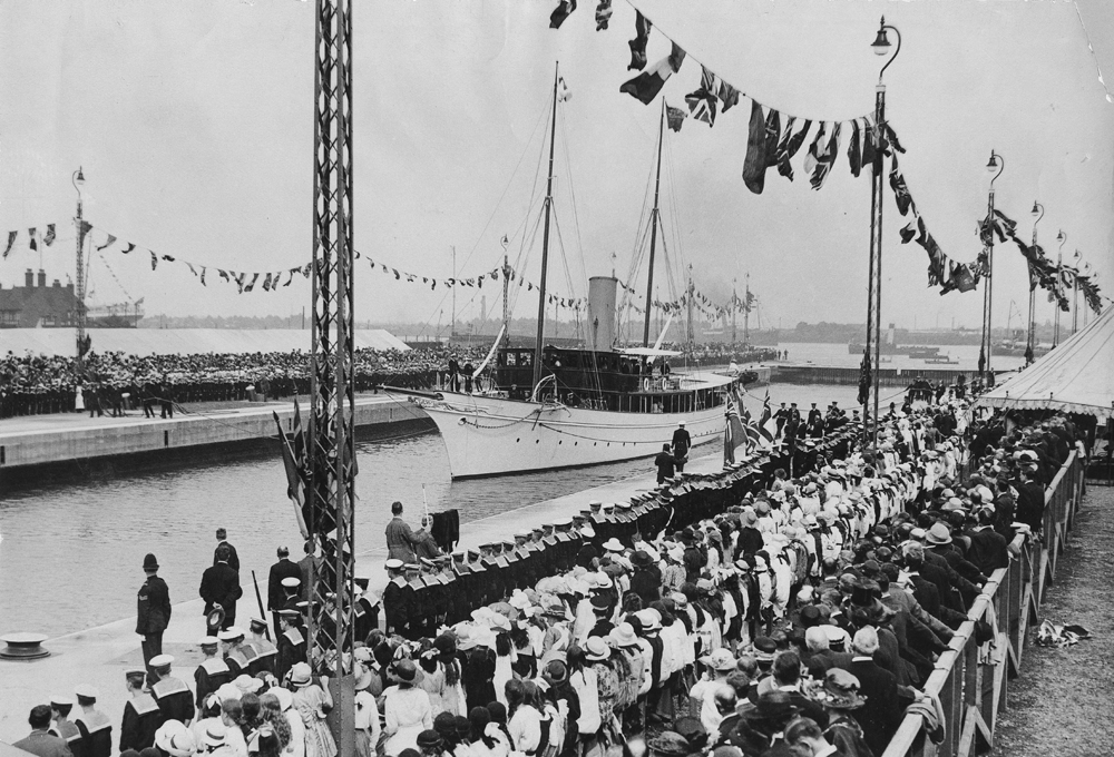 Dock lined with flags and sailors in uniform