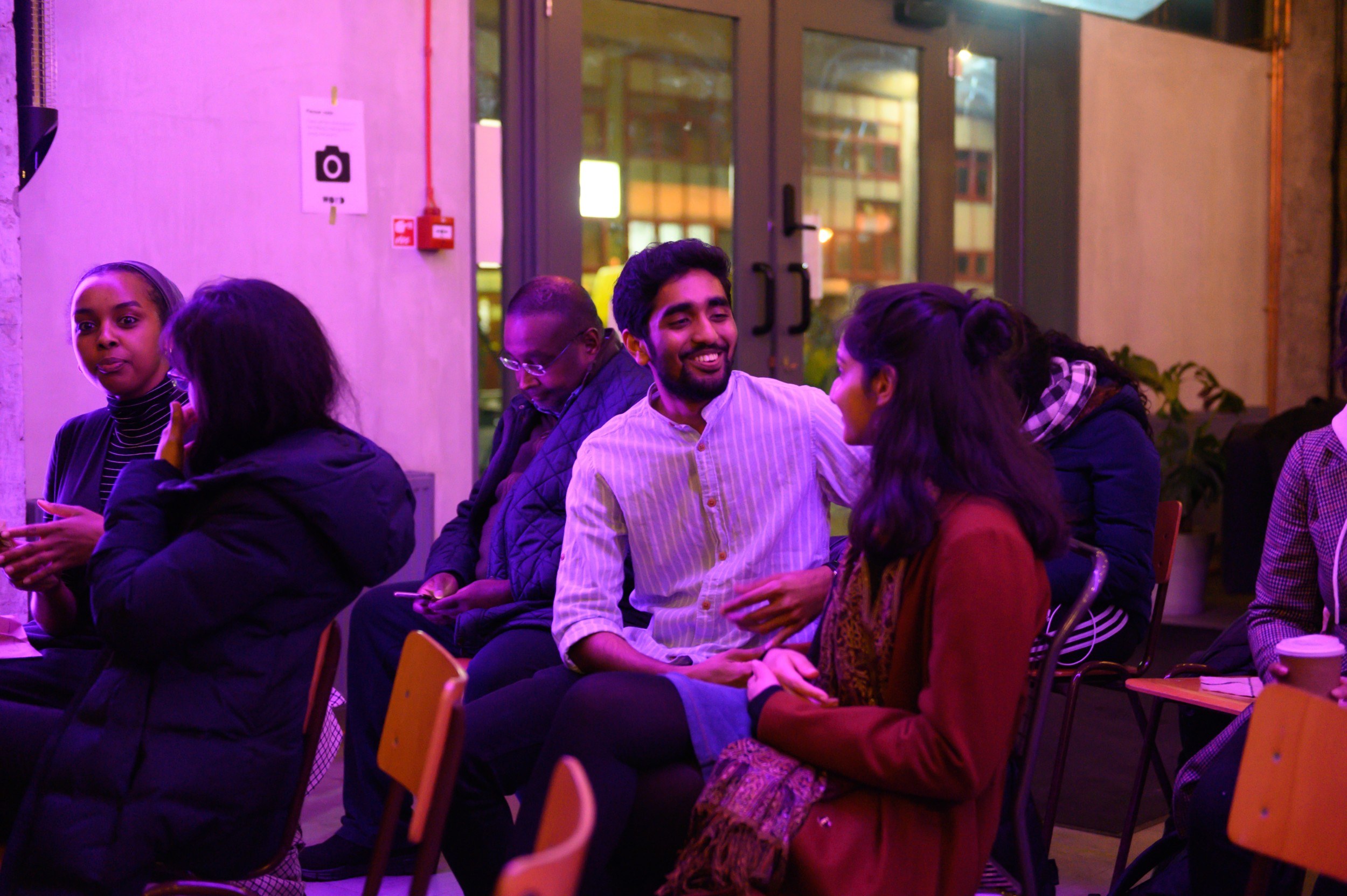 Audience members sat down and talking amongst themselves