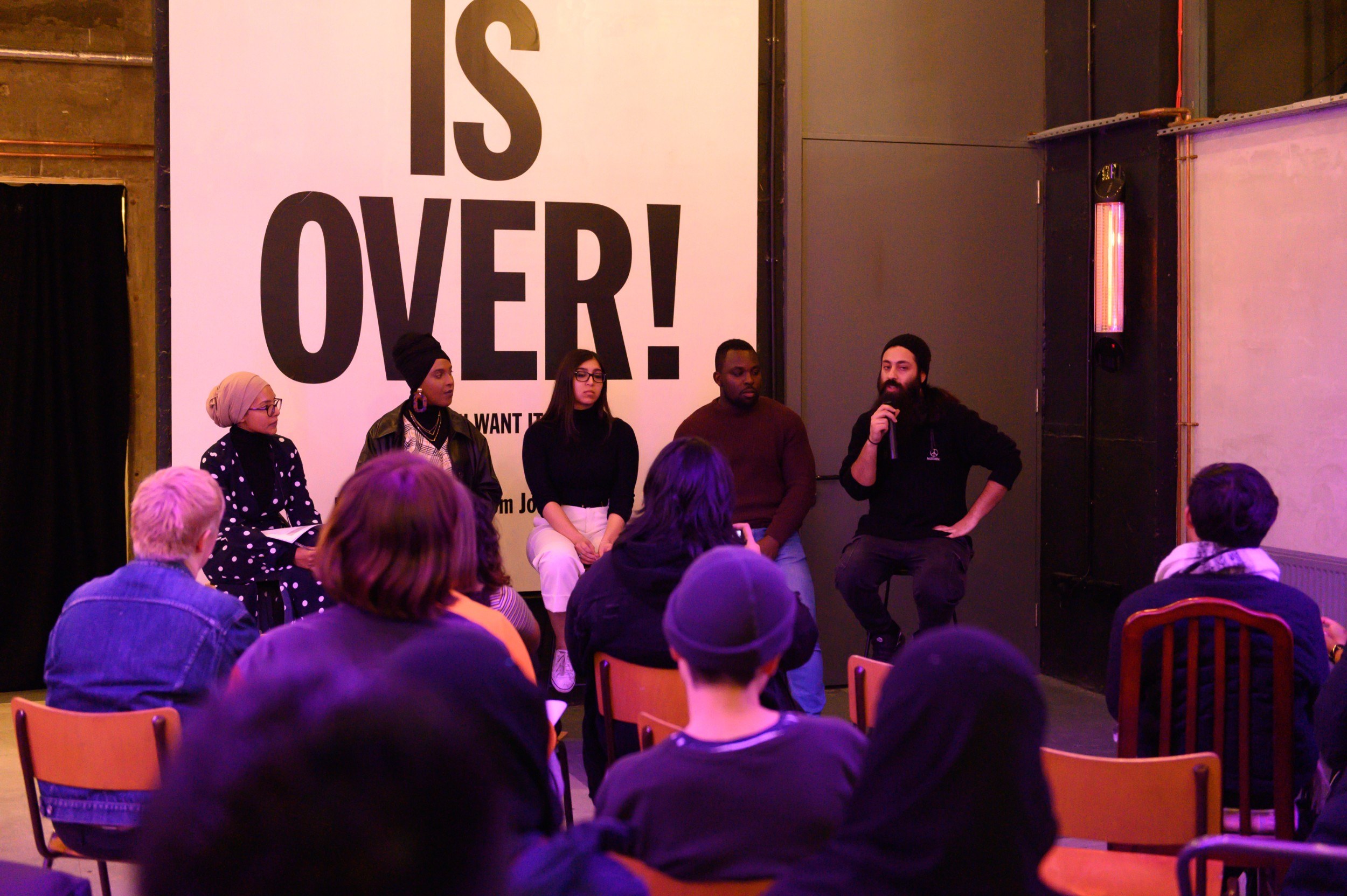 Panel of five people in front of an audience