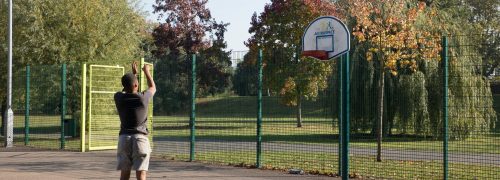 Teenager playing basketball in a park