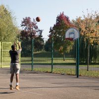 Teenager playing basketball in a park