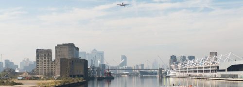 Panoramic view of the Royal Docks with a plane coming in to land