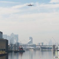 Panoramic view of the Royal Docks with a plane coming in to land