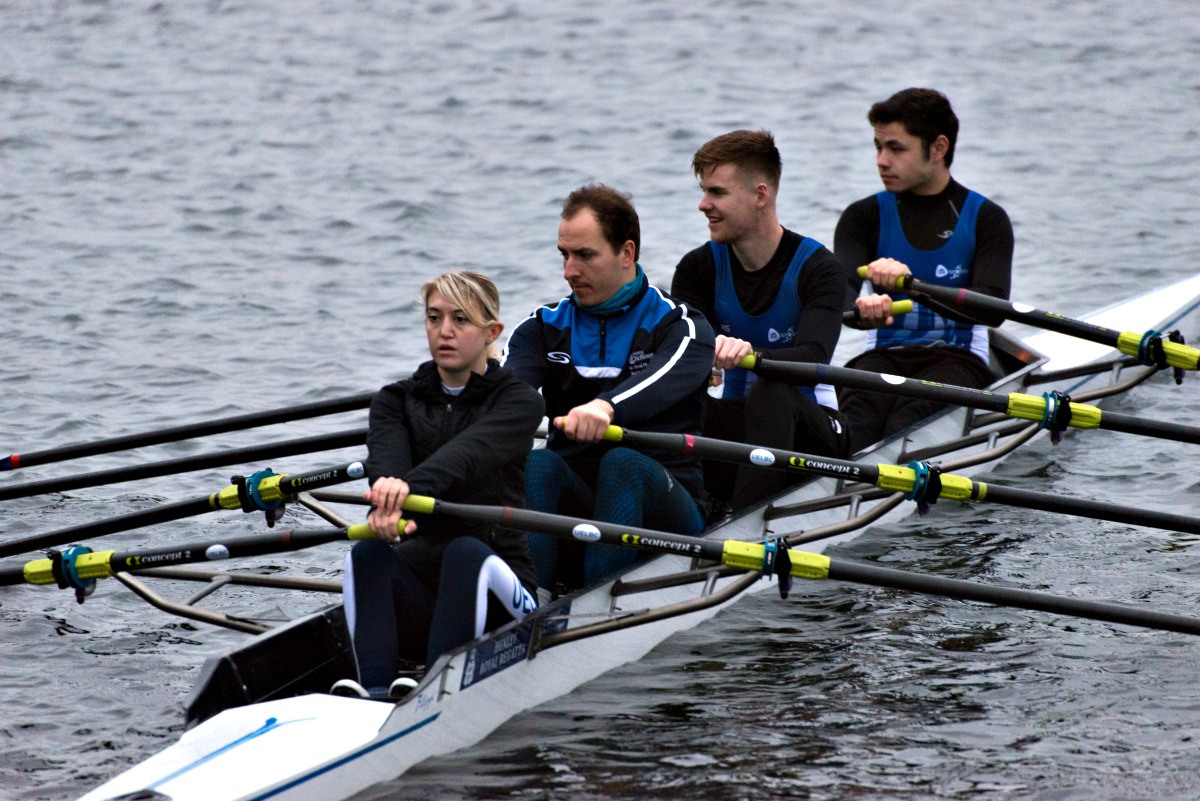 A team of four rowers in a canoe