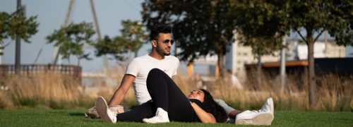 Two people relaxing in Thames Barrier Park