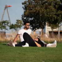 Two people relaxing in Thames Barrier Park