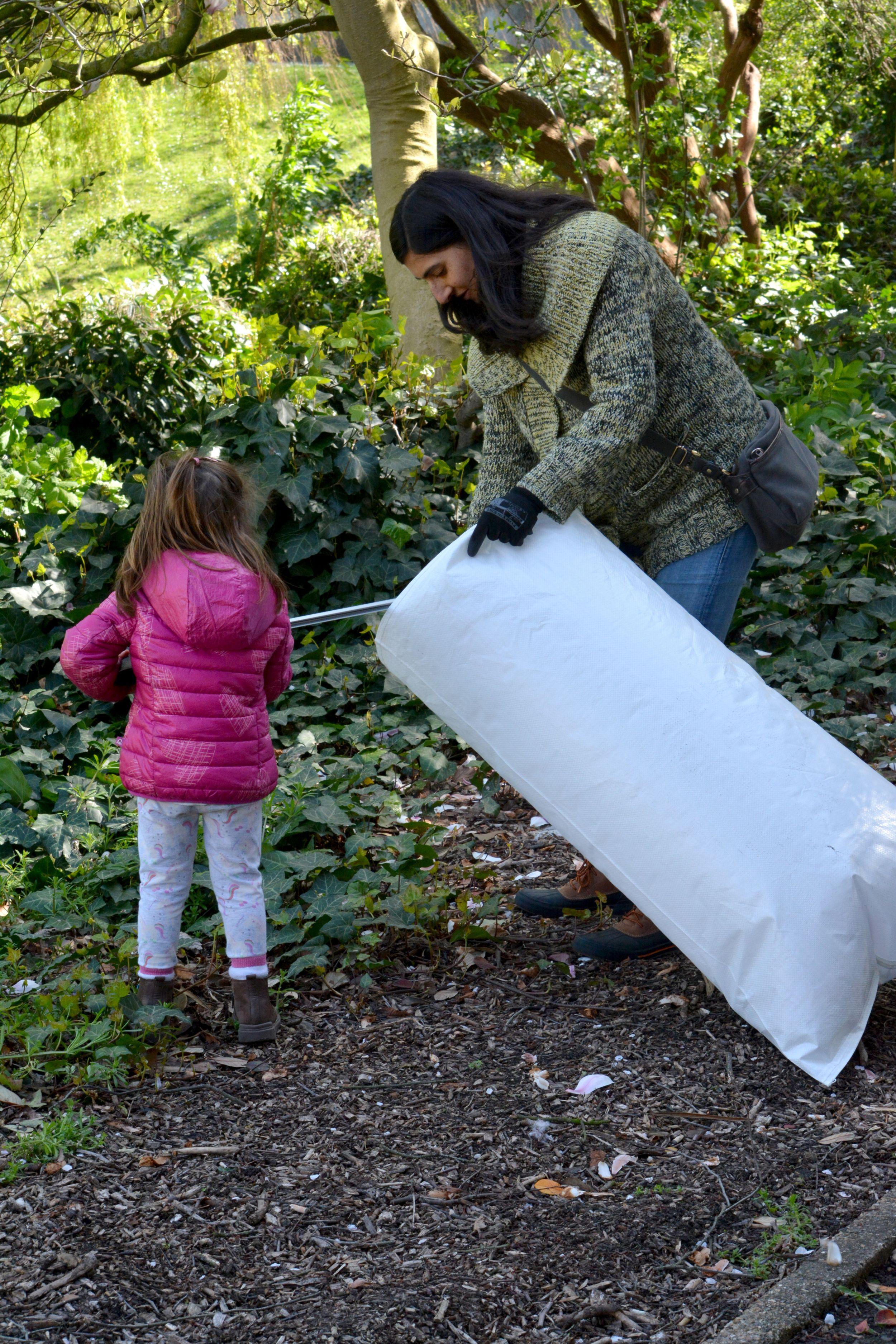 A woman and a child picking up litter in a refuse sack