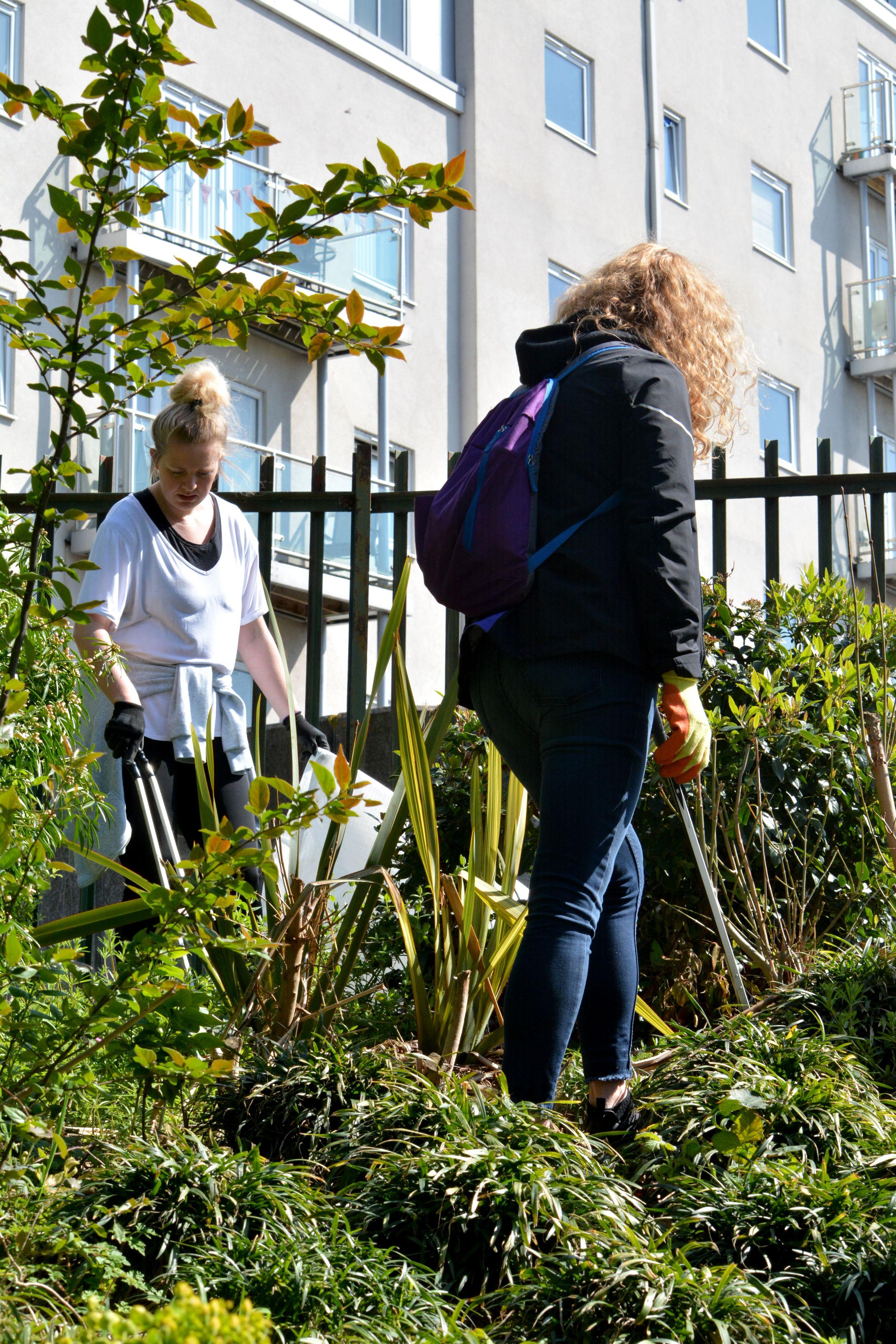 Two women participating in a beach clean up